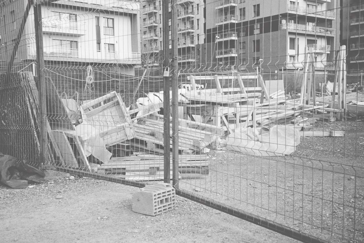 Wooden construction materials stored behind a fence